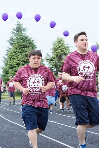 Young man with Down syndrome jogging with his brother