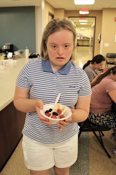 Person with Down syndrome holding a healthy snack