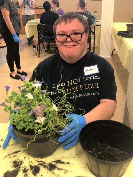 Person with Down syndrome with potted plant
