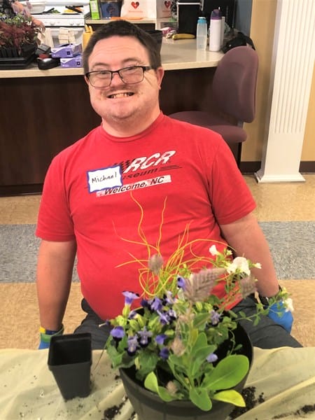 Person with Down syndrome with potted plant