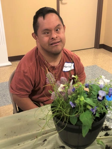 Person with Down syndrome with potted plant
