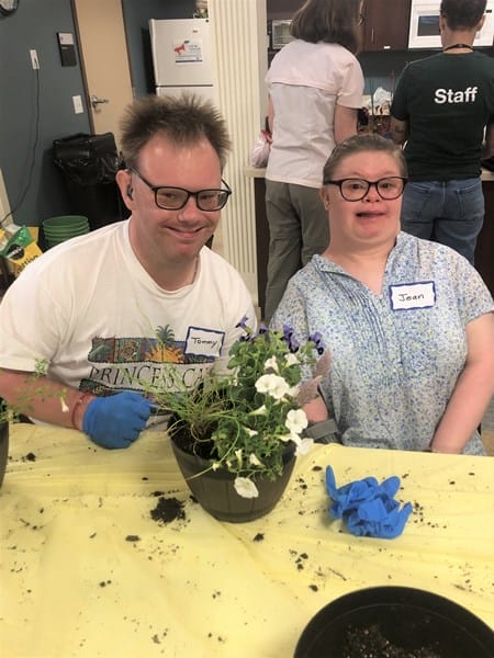 Person with Down syndrome with potted plant