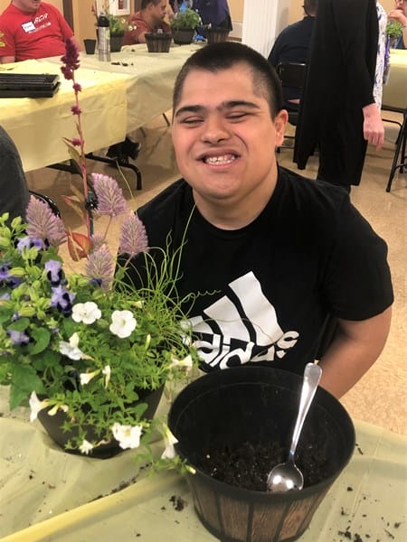 Person with Down syndrome with potted plant