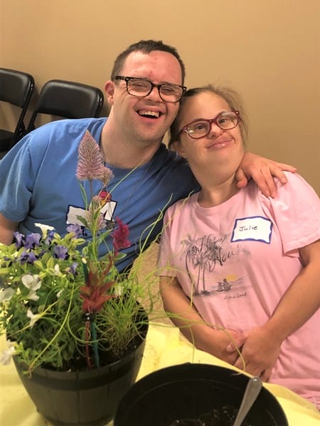 Person with Down syndrome with potted plant