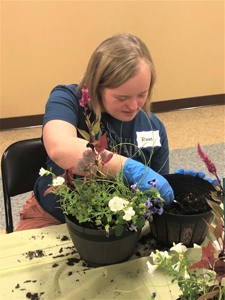 Person with Down syndrome with potted plant